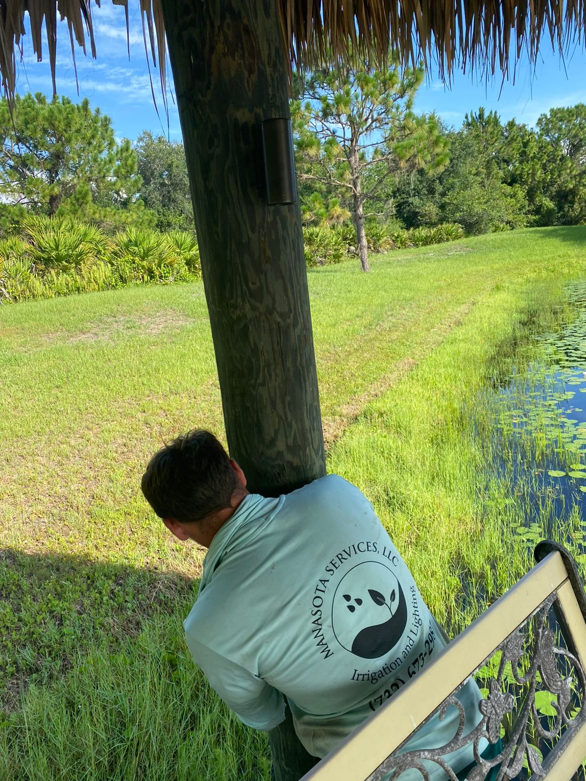 Manasota Services technician mounting a light