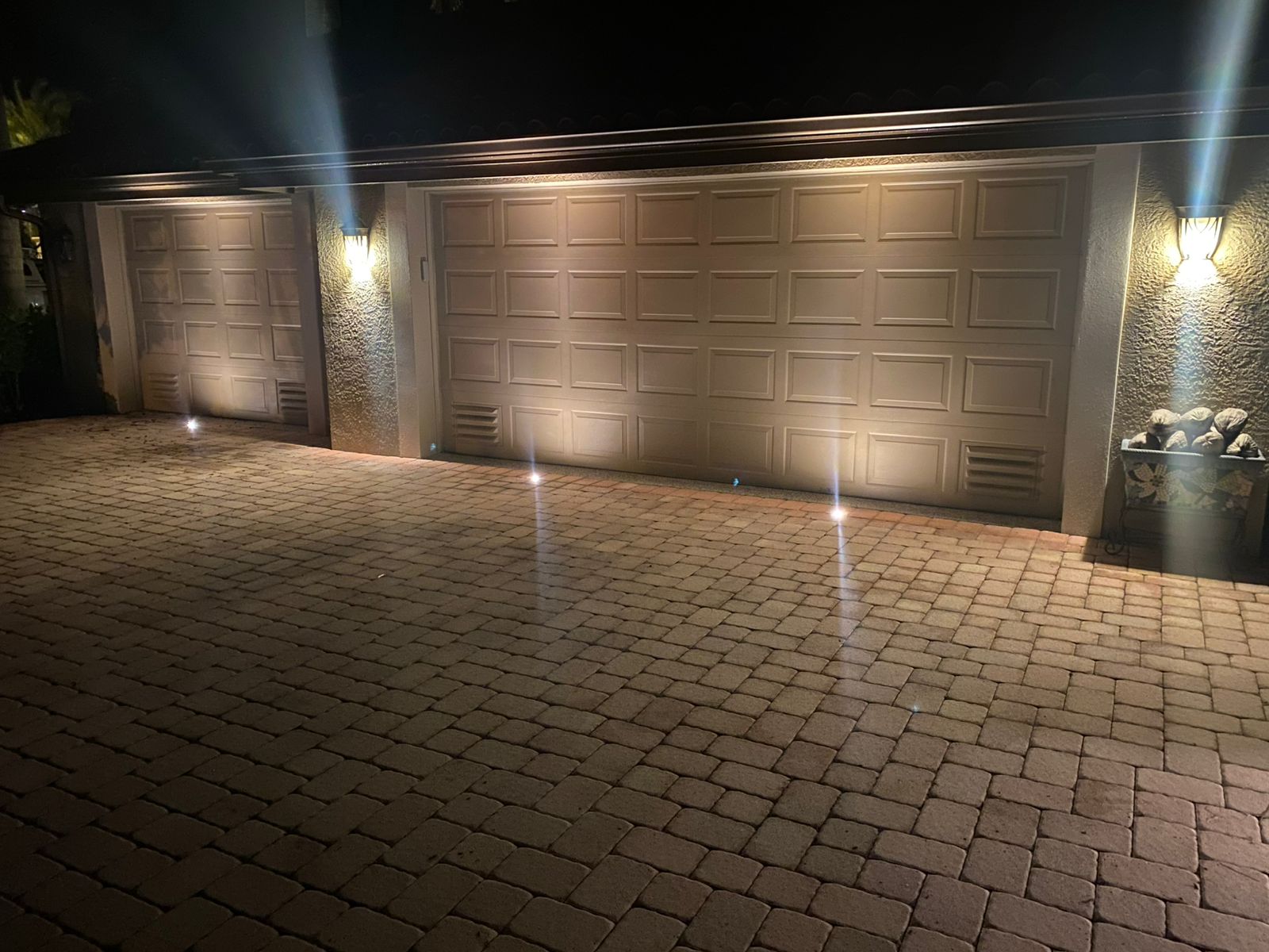 Garage elevation lit with wall sconces and in-ground lights